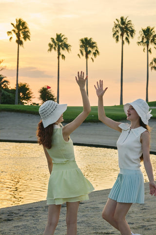FAIRLIAR 26SS editorial - two pastel golf outfits in yellow and mint at sunset