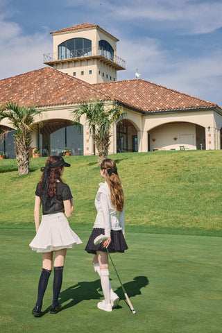FAIRLIAR 26SS editorial - two golfers in layered outfits with knee socks at the clubhouse